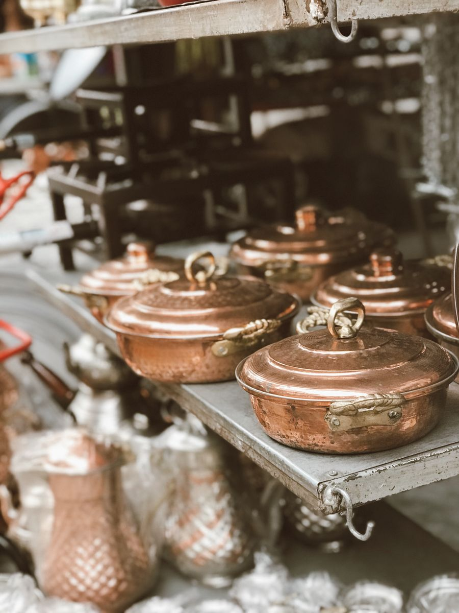 Casseroles en cuivre patinées alignées sur une étagère