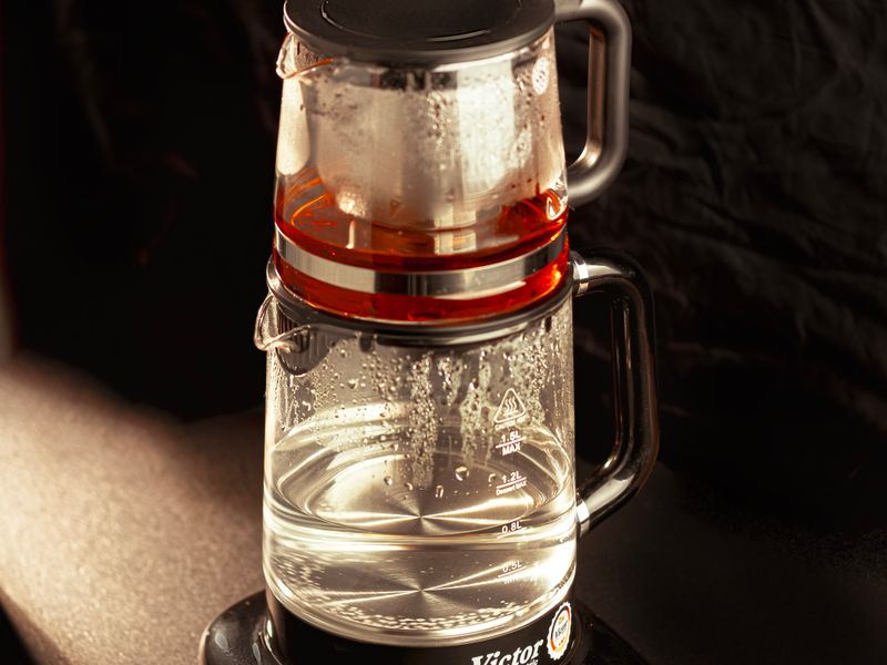 Bouilloire en verre avec de l'eau bouillante, vapeur visible