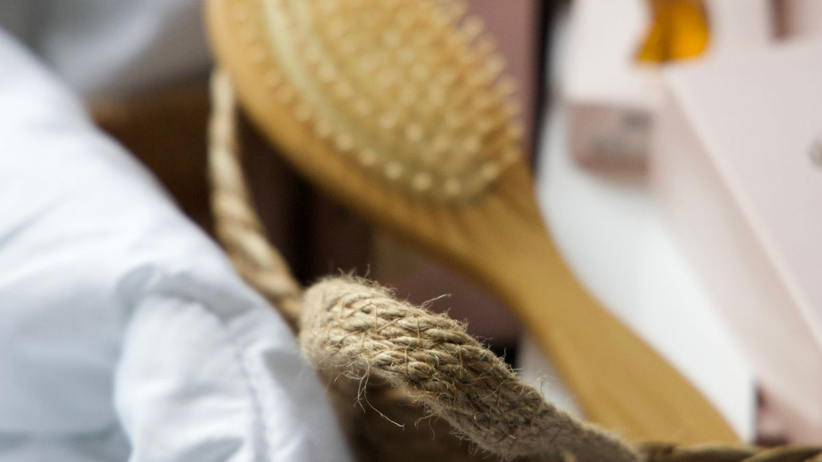 Brosse à cheveux en bois posée dans un panier en osier