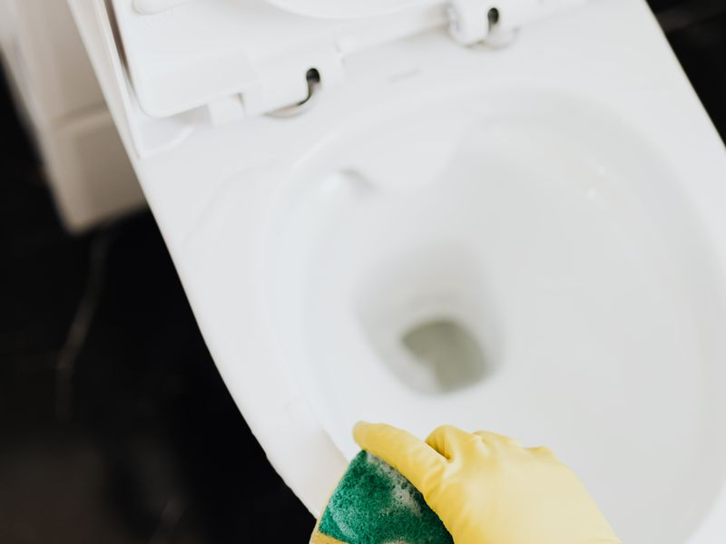 Nettoyage du rebord des toilettes à l'éponge
