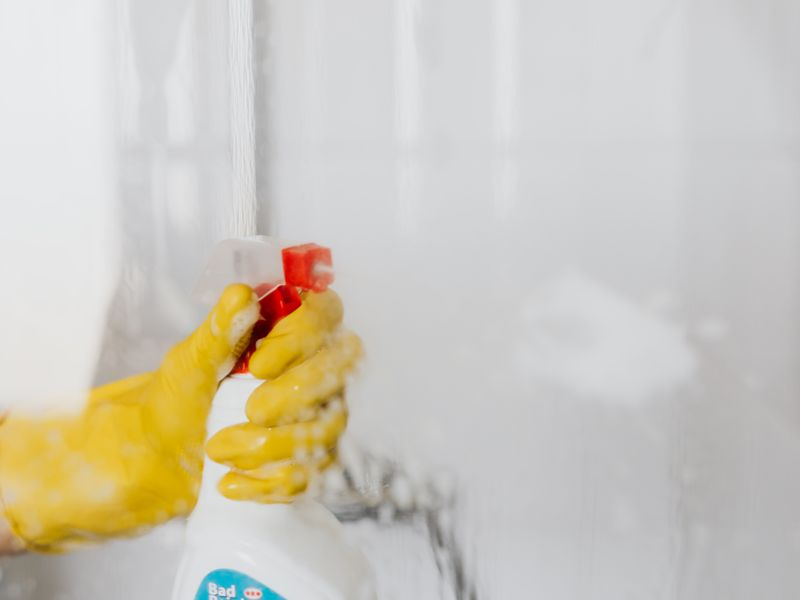 Vaporisation de détergent sur une paroi de douche vitrée